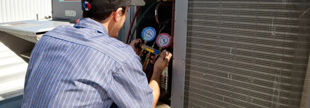 HVAC technician servicing a condenser unit in Oakleaf Plantation